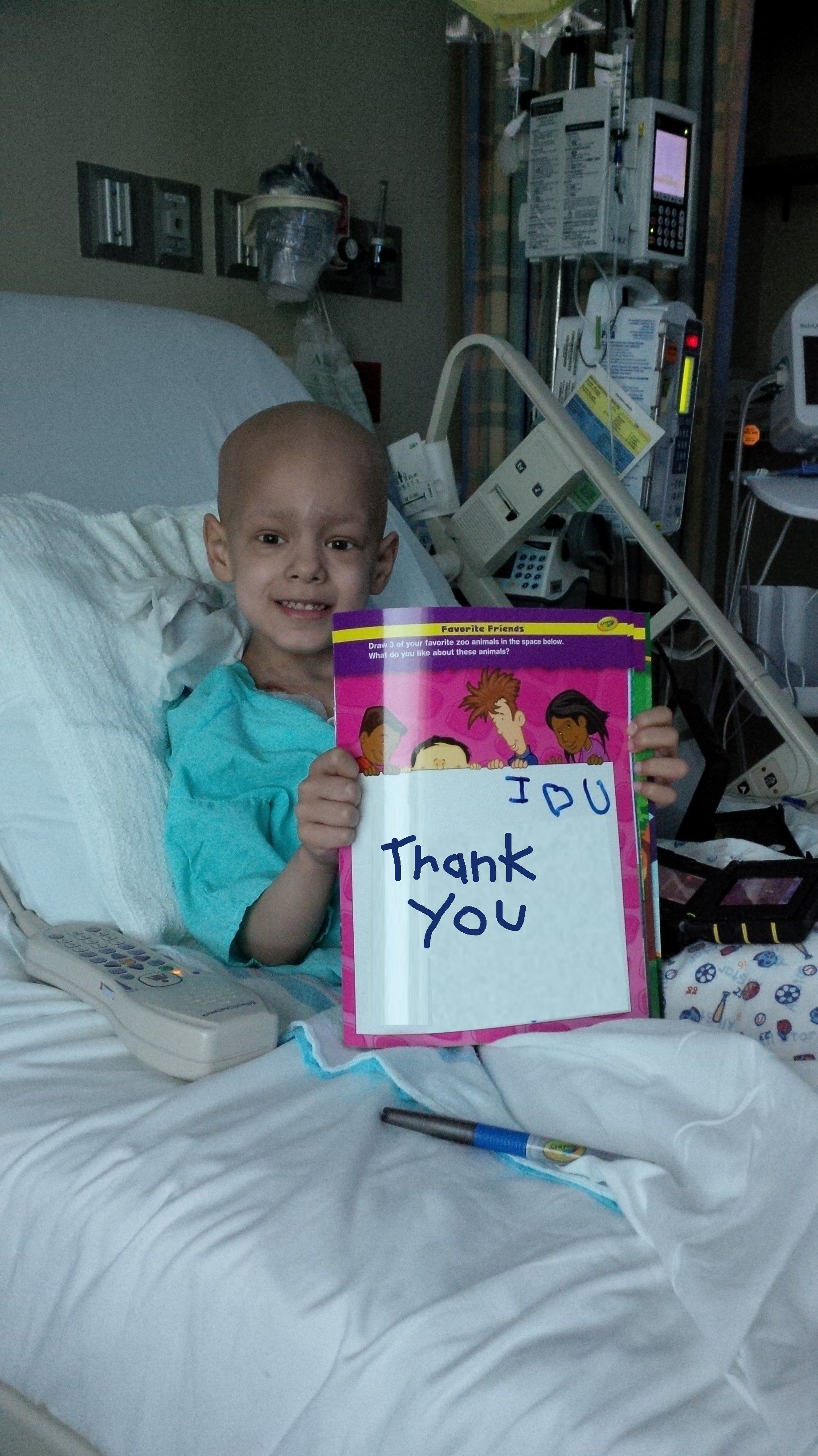 Nick in the hospital holding a Thank You sign